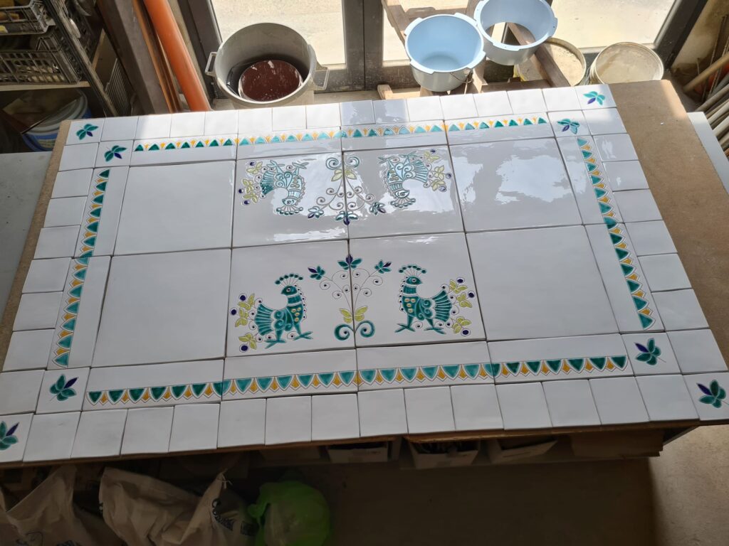 Andrea Farci, ceramiche artistiche artigianali: pannelli con pavoncelle, per un bellissimo tavolo in ferro battuto